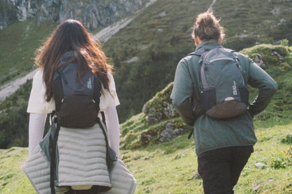 Photo estivale de deux randonneurs de dos avec des sacs à dos de randonnée au look sportif